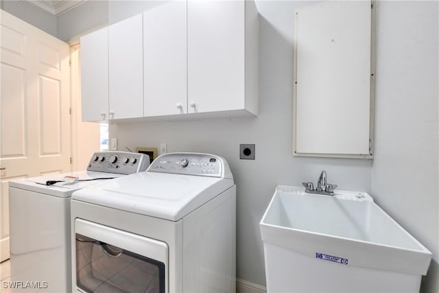 laundry area with cabinets, ornamental molding, sink, and washing machine and dryer