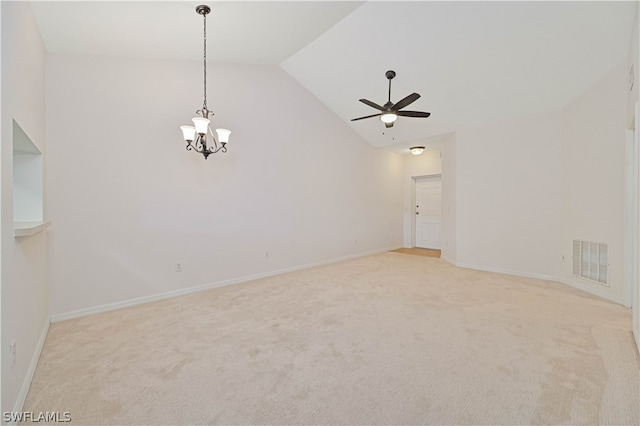 carpeted empty room featuring lofted ceiling and ceiling fan with notable chandelier