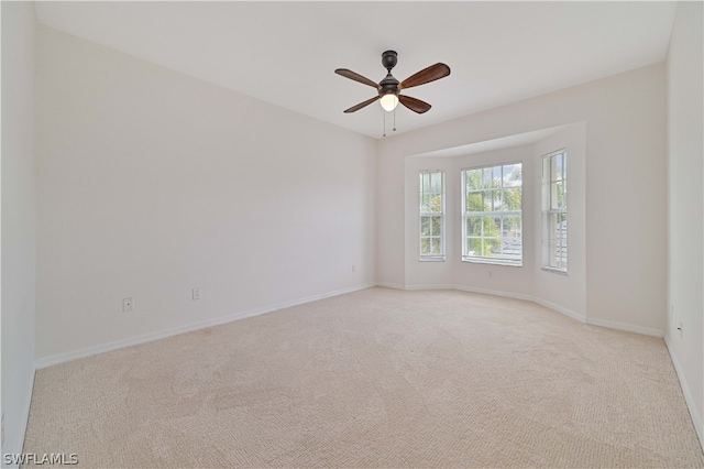 unfurnished room featuring ceiling fan and light colored carpet