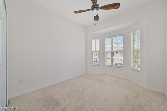 carpeted spare room with ceiling fan