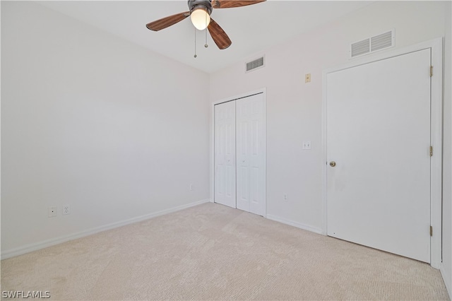 unfurnished bedroom with light carpet, ceiling fan, and a closet