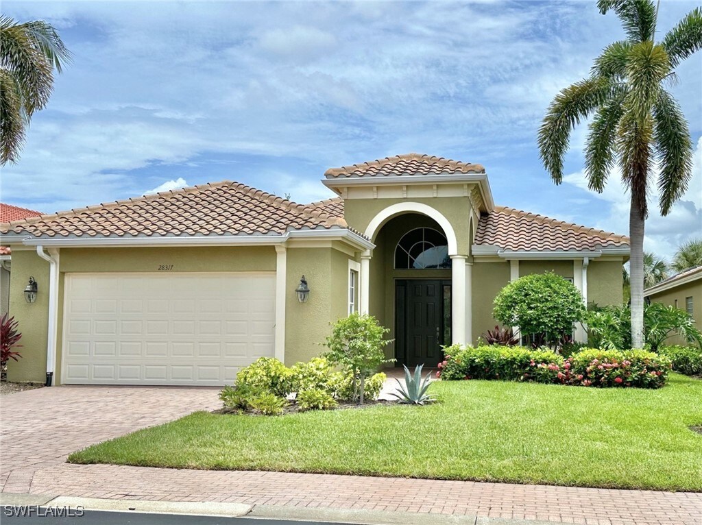 mediterranean / spanish-style house featuring a garage and a front yard