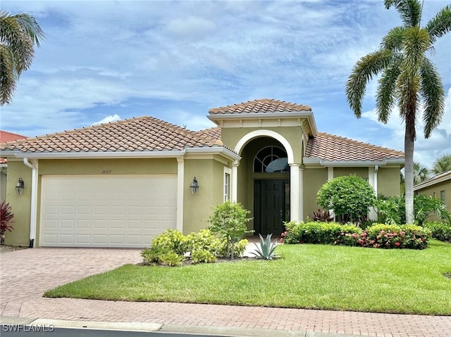 mediterranean / spanish-style house featuring a garage and a front yard