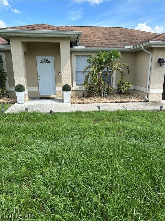 entrance to property with a lawn