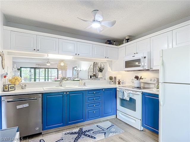 kitchen featuring ceiling fan, sink, blue cabinets, white appliances, and light wood-type flooring