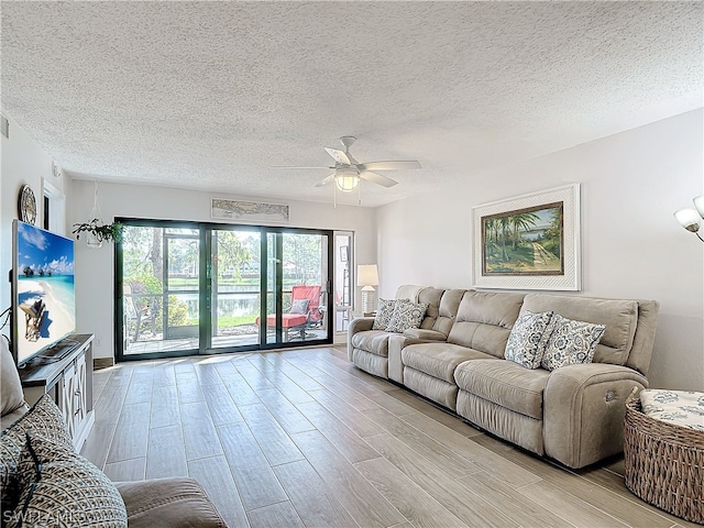 living room featuring a textured ceiling, light hardwood / wood-style floors, and ceiling fan with notable chandelier