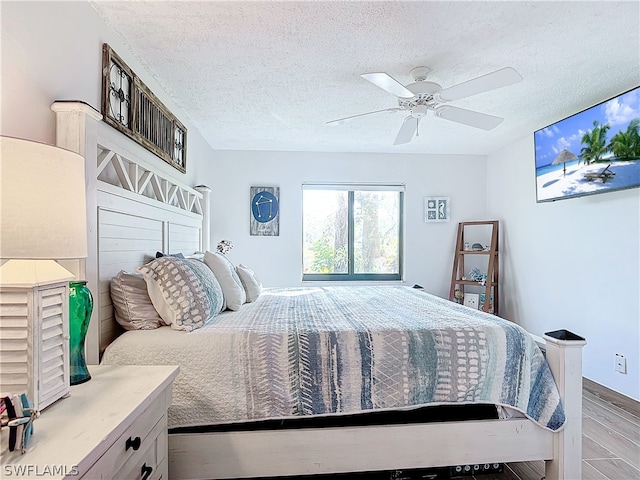 bedroom with a textured ceiling, light hardwood / wood-style floors, and ceiling fan