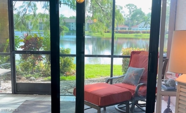 doorway to outside with tile patterned floors, a healthy amount of sunlight, and a water view