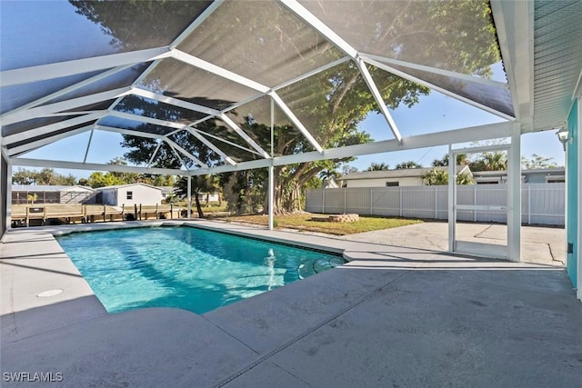 view of pool with glass enclosure and a patio area