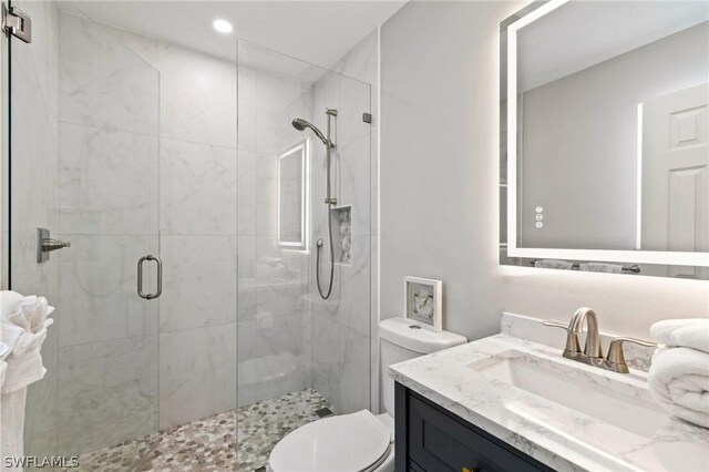 bathroom featuring walk in shower, vanity, and toilet