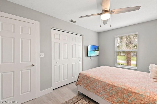 bedroom featuring light wood-type flooring, ceiling fan, and a closet