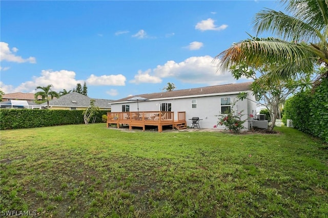 rear view of house with a wooden deck and a yard