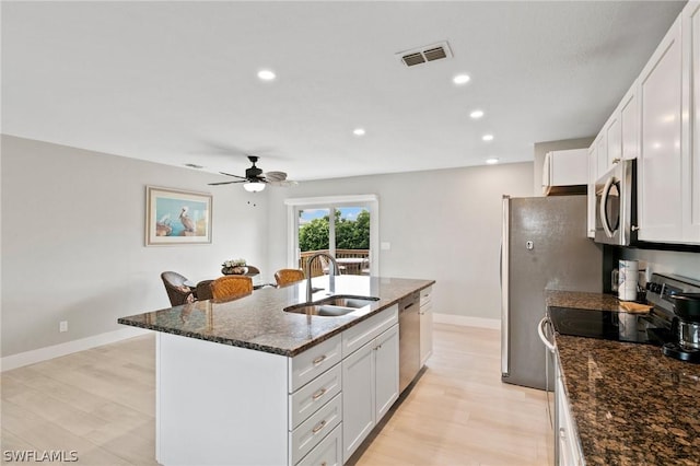 kitchen featuring a kitchen island with sink, sink, stainless steel appliances, and white cabinets