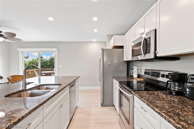 kitchen with sink, white cabinetry, dark stone countertops, ceiling fan, and stainless steel appliances