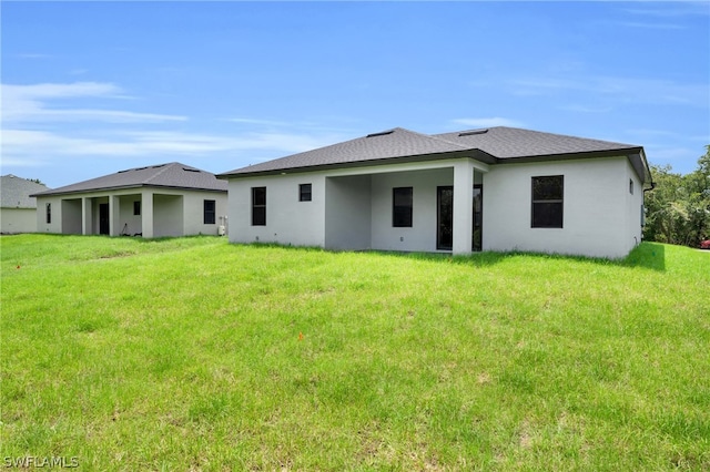 rear view of property with a lawn