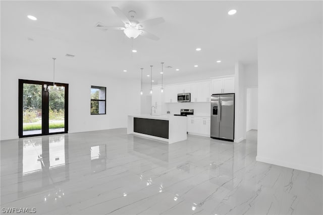 kitchen with appliances with stainless steel finishes, white cabinetry, ceiling fan, and decorative light fixtures