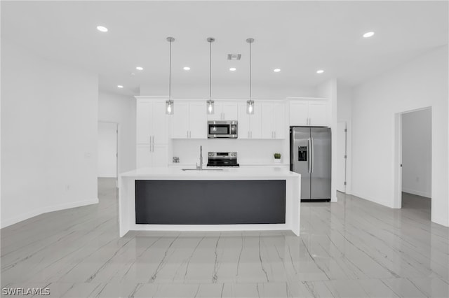 kitchen featuring pendant lighting, a kitchen island with sink, sink, white cabinetry, and stainless steel appliances