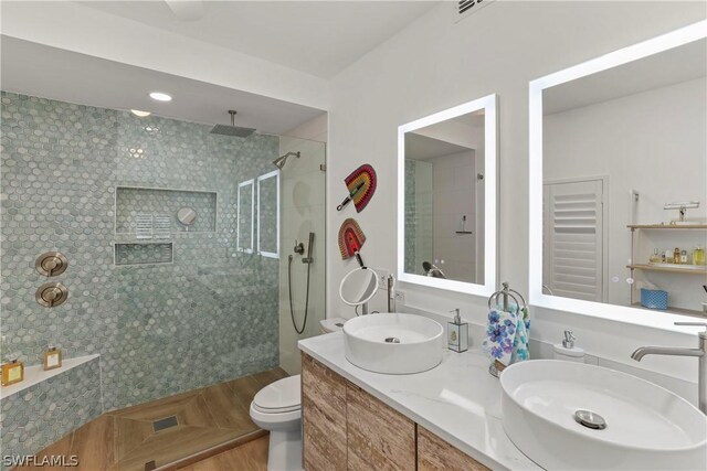 bathroom with double vanity, walk in shower, and toilet