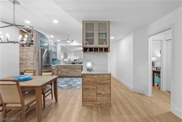 kitchen featuring stainless steel fridge, a notable chandelier, and light hardwood / wood-style flooring