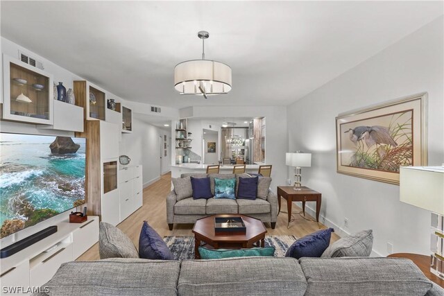 living room with light hardwood / wood-style flooring and an inviting chandelier