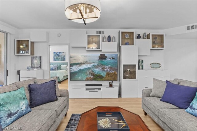 living room featuring an inviting chandelier and light hardwood / wood-style floors