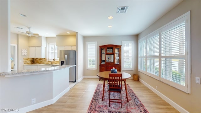 dining space featuring ceiling fan, a healthy amount of sunlight, and light hardwood / wood-style floors