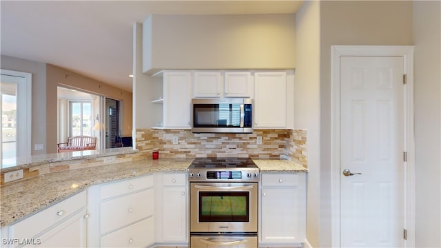 kitchen featuring light stone counters, white cabinetry, backsplash, and appliances with stainless steel finishes