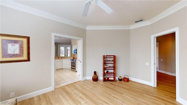 unfurnished room featuring ceiling fan, light hardwood / wood-style floors, and ornamental molding