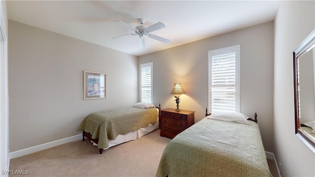 bedroom with ceiling fan, light colored carpet, and multiple windows