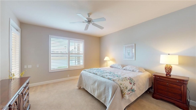 bedroom with ceiling fan and light carpet