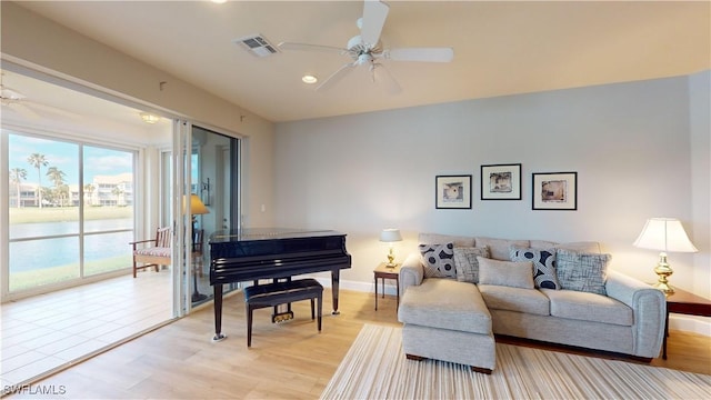 living room featuring ceiling fan and light hardwood / wood-style flooring