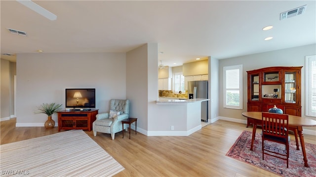 living room with light hardwood / wood-style floors and vaulted ceiling