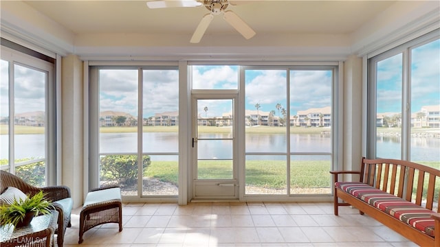 sunroom / solarium with ceiling fan, a water view, and a healthy amount of sunlight