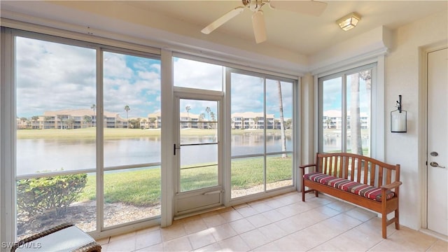 sunroom featuring ceiling fan, plenty of natural light, and a water view