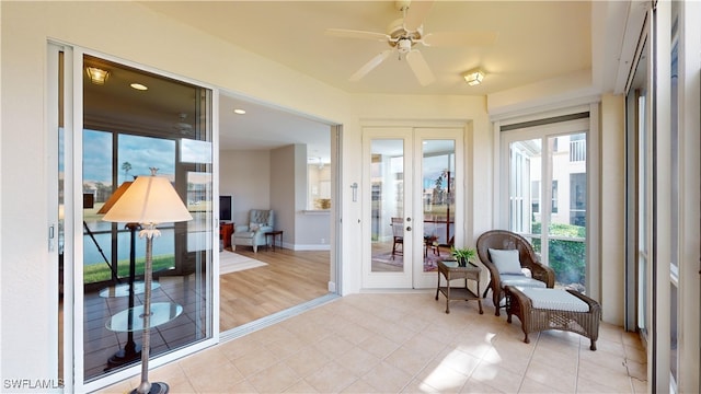 sunroom / solarium featuring ceiling fan and french doors