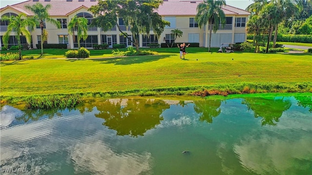 surrounding community featuring a lawn and a water view