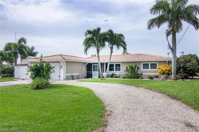 ranch-style home featuring a garage and a front lawn