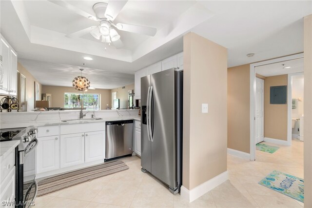 12520 Kelly Greens Blvd Unit 342, Fort Myers, FL 33908 - kitchen featuring a tray ceiling, stainless steel appliances, light countertops, white cabinetry, and a peninsula