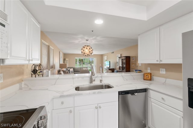 kitchen featuring open floor plan, stainless steel appliances, a sink, and white cabinetry