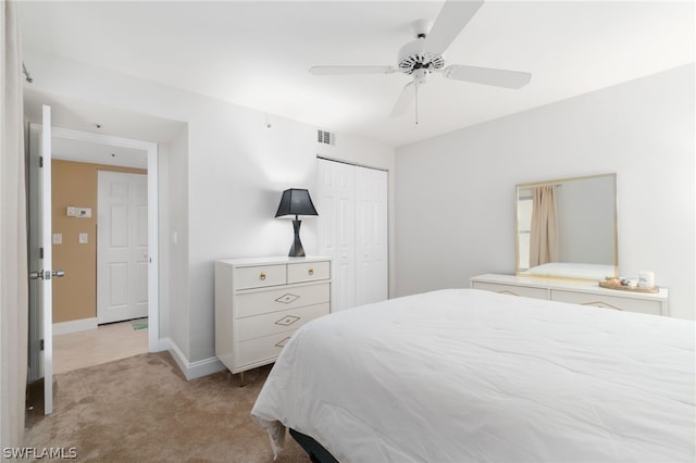 carpeted bedroom featuring ceiling fan and a closet