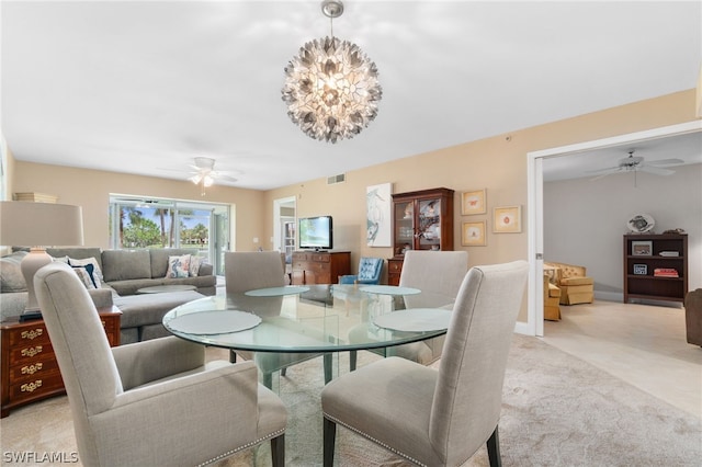 carpeted dining space featuring ceiling fan with notable chandelier