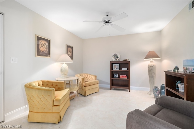 living area with visible vents, a ceiling fan, and baseboards