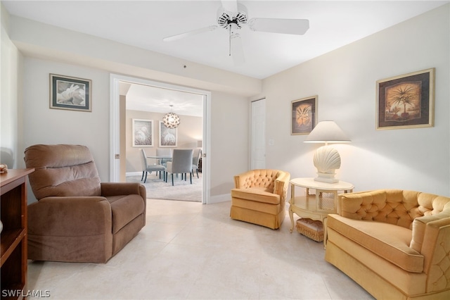 living area featuring baseboards, a ceiling fan, and light tile patterned flooring