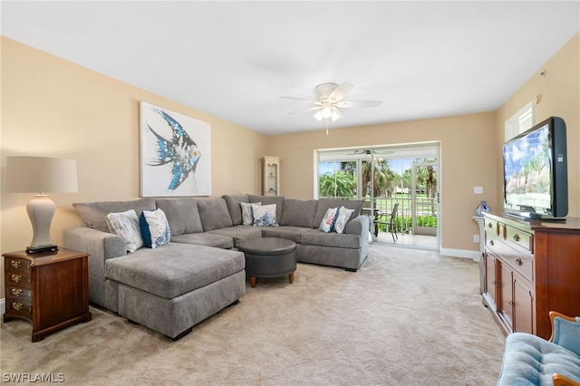 living room featuring light colored carpet, ceiling fan, and baseboards