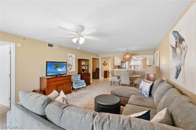 living room featuring visible vents, a ceiling fan, and light colored carpet