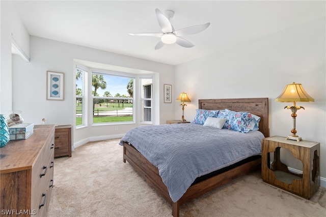 bedroom with a ceiling fan, light colored carpet, and baseboards