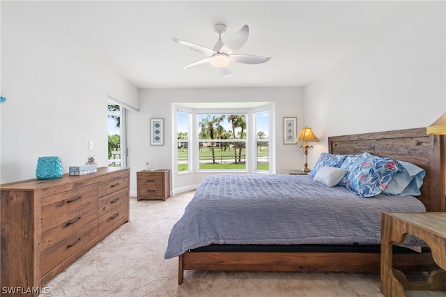 bedroom with light carpet, access to exterior, and a ceiling fan