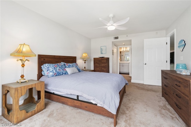 bedroom with a ceiling fan, light carpet, visible vents, and ensuite bath