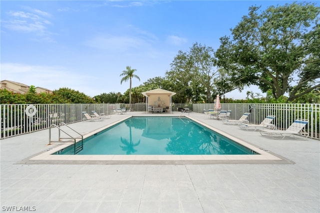 community pool with a patio and fence