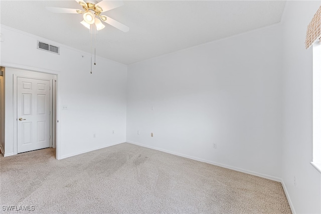 spare room featuring ceiling fan, visible vents, baseboards, and light colored carpet